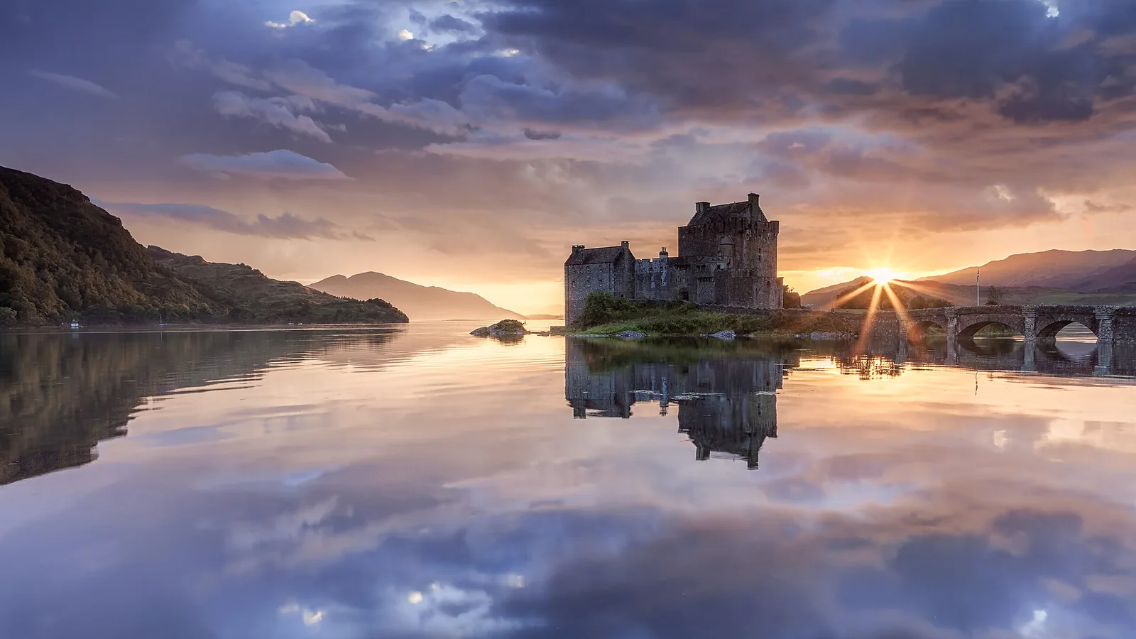 Eilean Donan Castle reflected in calm water at sunset