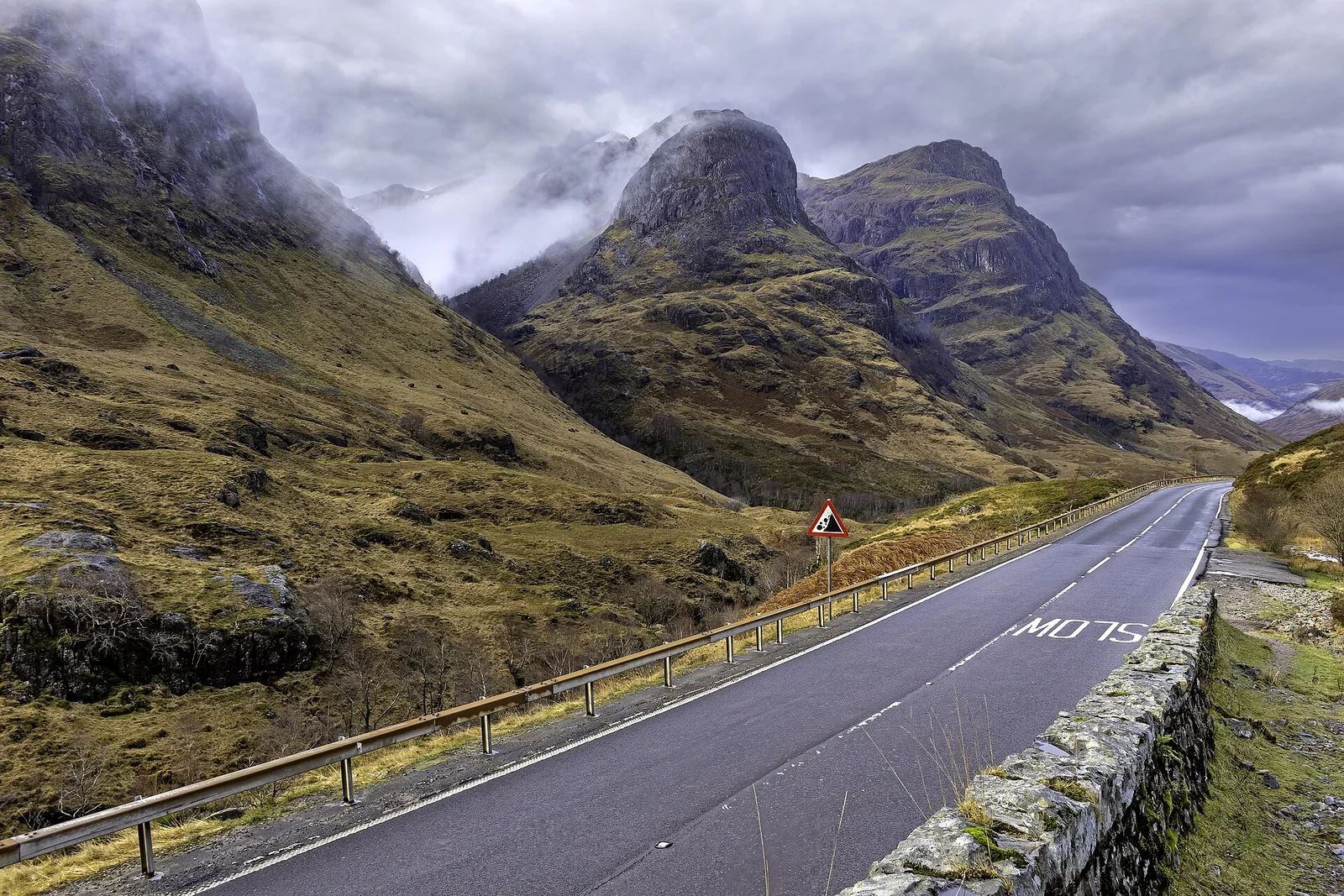 The road through Glencoe beneath the misty Three Sisters mountains