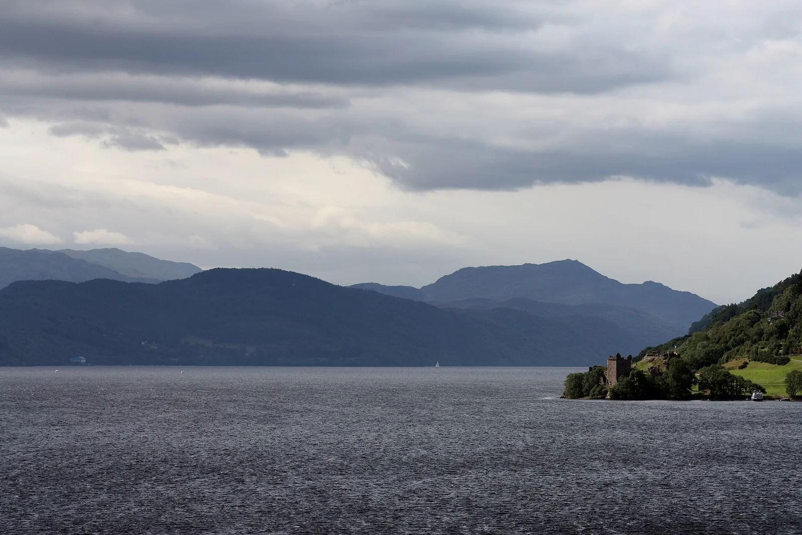 Loch Ness beneath brooding clouds with Urquhart Castle on the shoreline
